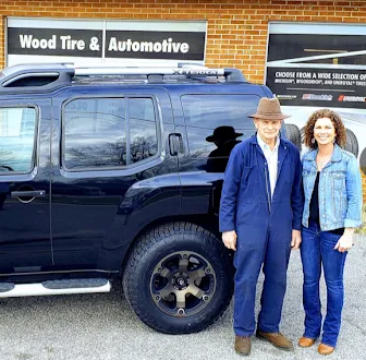 The Wood family waving hello in front of Wood Tire & Automotive